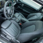 Custom BMW Mini Cooper seat covers in black leatherette with contrast stitching installed in a Mini cabin