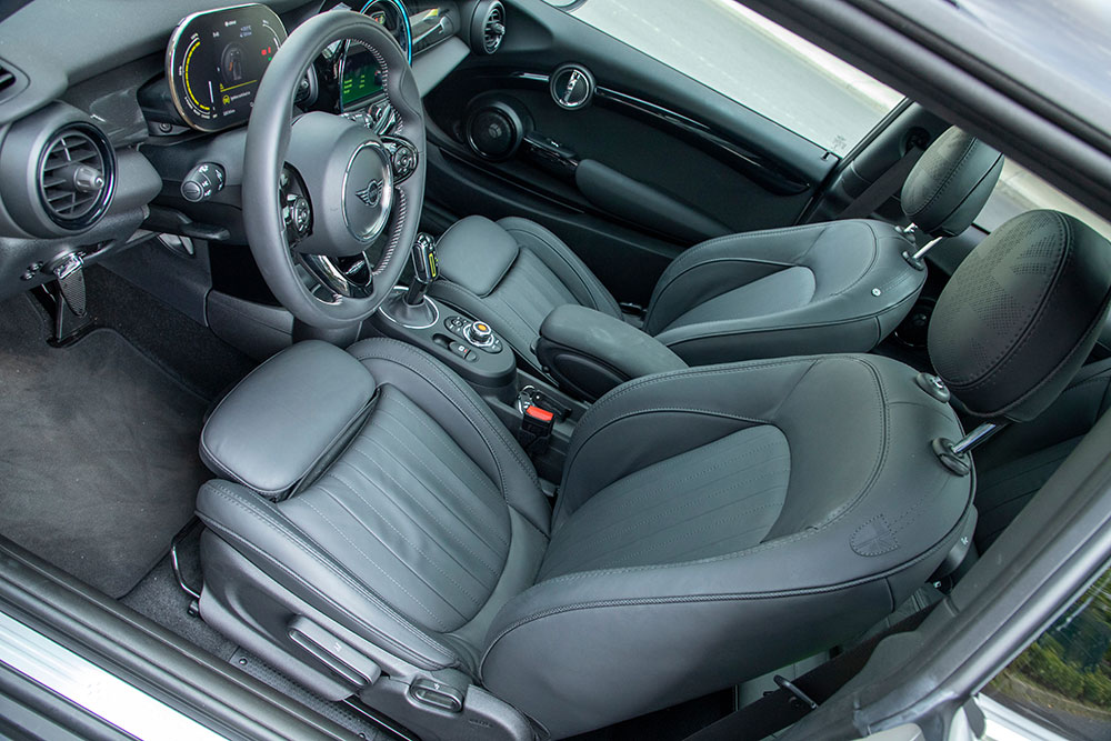 Custom BMW Mini Cooper seat covers in black leatherette with contrast stitching installed in a Mini cabin