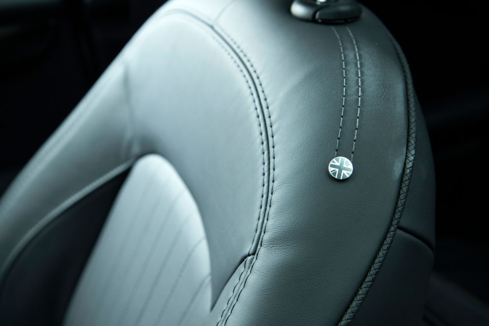 Custom BMW Mini Cooper seat covers in black leatherette with contrast stitching installed in a Mini cabin
